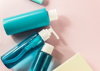 Flat lay composition with cosmetic products and accessories on a pink pastel background. Top view