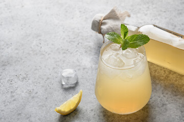Kombucha with lemon on gray background. Organic healthy probiotic beverage. Close up.