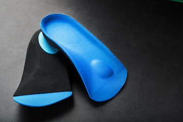 Orthopedic insoles for correction of pronation of the foot on a dark background.