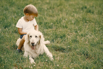 Little boy playing with his dog on a grass