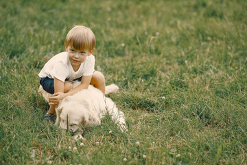 Little boy playing with his dog on a grass