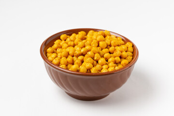 Traditional Indian crispy, salty, savory snack - roasted  chickpeas, sprinkled with spices in a clay bowl isolated on a white background