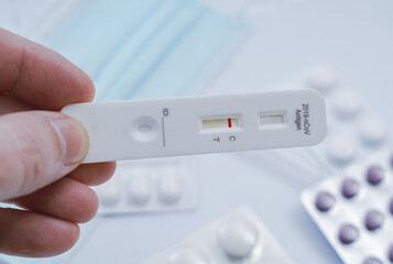 Negativetest result by using rapid test device for COVID-19. Express corona test at home: Close up of man holding a negative covid antigen test.