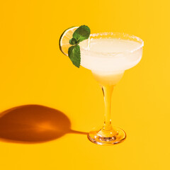 Margarita glass isolated on bright yellow neon background with shadow. Concept of taste, alcoholic drinks