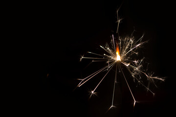 Fototapeta premium Bengal fire on a dark background, sparks of celebration.