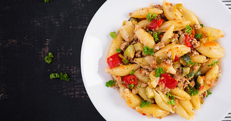 Conchiglie pasta. Italian pasta shells with minced meat, zucchini, tomato and sweet peppers. Top view, above