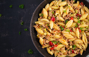 Conchiglie pasta. Italian pasta shells with minced meat, zucchini, tomato and sweet peppers. Top view, above