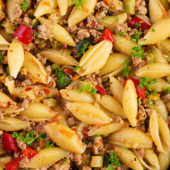 Conchiglie pasta with minced meat, zucchini, tomato and sweet peppers. Texture, background