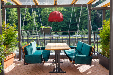 table and benches in a summer cafe against the backdrop of green foliage