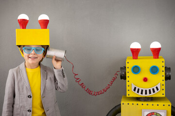 Happy child playing with robot