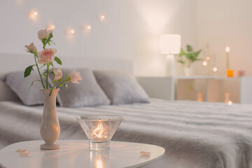 pink roses in vase on table in bedroom