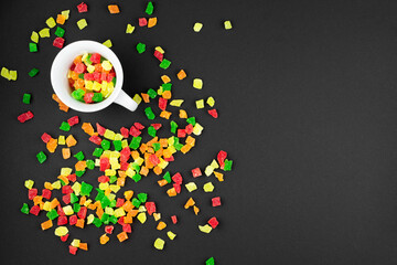 multicolored candied fruits from a white cup