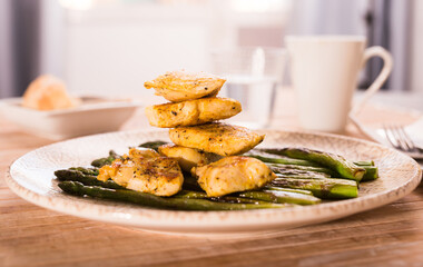 fried chicken breast pieces with asparagus on white plate