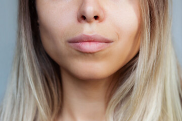 Close up of a lower part of a young caucasian blonde woman's face with clear highlighted cheekbones...