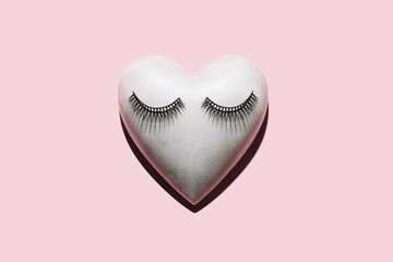 Concrete/plaster heart with eyelashes makeup on pastel pink background. Minimalist Valentines Day Concept.Love background.