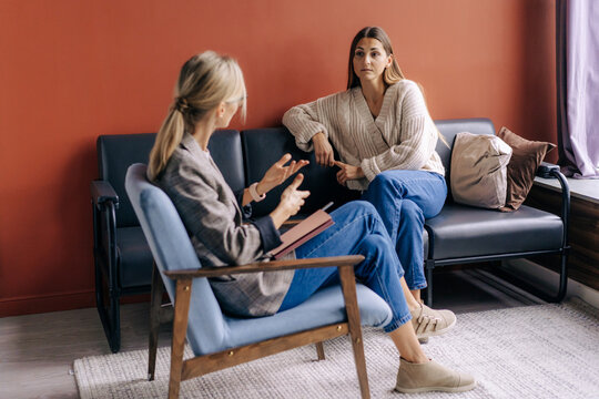 A female psychotherapist consults and gives advice and psychological support to a young female patient.