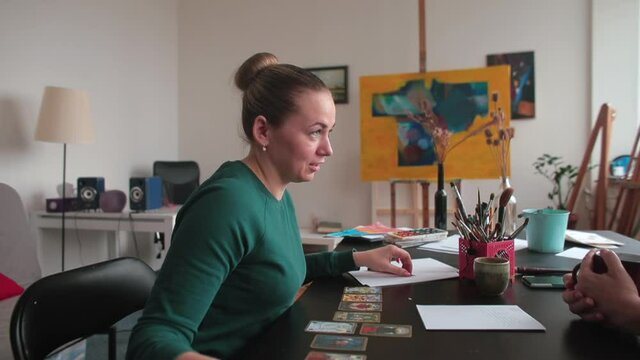 A conversation with a psychologist. The patient is talking at the table. She uses gestures. Talk about mental problems.