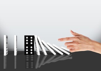 Domino blocks and human hand on the desk