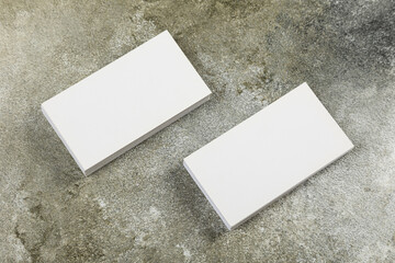 Photo of a stack of blank business cards on a stone table. Template for identity card.