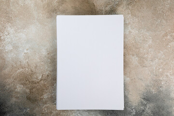 several sheets of paper in a pile of a4 a5 business card on a grunge table.