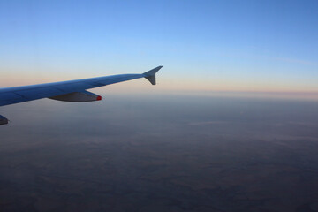 Fototapeta na wymiar Sunset sky on airplane, plane window, over Europe in Friday evening flight for relax in holiday