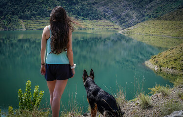 girl with backpack and pet by a lake