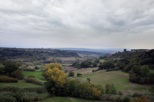 The rural green landscape of the Marta Valley, with the backdrop of the Cimini Mountains and the Tolfa, from the terrace of the belvedere, Tuscania, Tuscia, Lazio, Italy