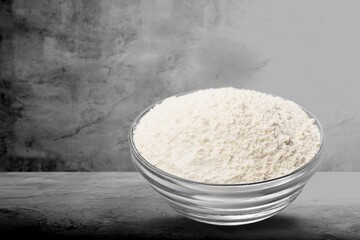 Pile of flour, on dark or black background. Spilled flour. Flour texture.