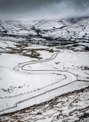 Fototapeta na wymiar Winding road through a snowy landscape with hills
