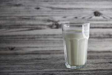 Glass of fresh milk on the wooden vintage background with copy space. Organic milk. Healthy wellness background