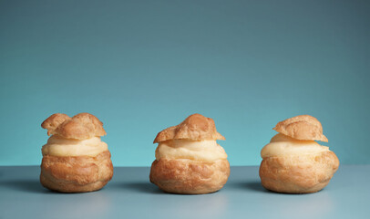 Three profiteroles on cyan background