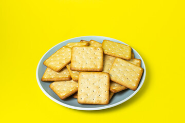 Crackers on a yellow background. Fresh crispy crackers on a plate.