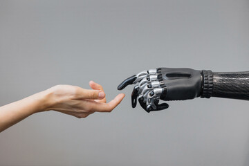 the human hand and the siber hand bionic prosthesis make a handshake and greeting. modern technologies of prosthetics of limbs of hands and feet. full life of people with amputated limbs. black bionic