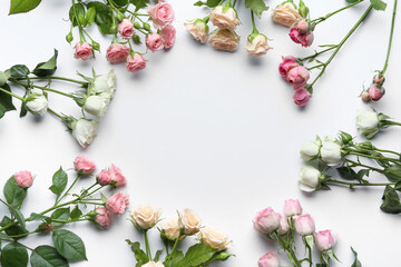 Frame made of beautiful roses on white background