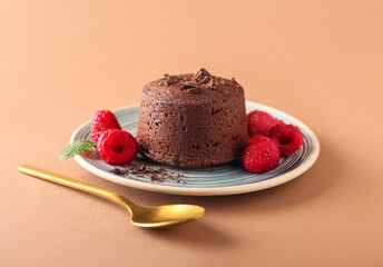 Plate with tasty lava cake fondant and raspberry on color background