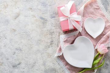 Beautiful table setting for Valentine's Day, gift box and tulip flower on light grunge background