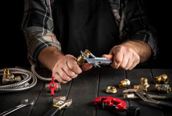 The plumber measures diameter of fitting with a caliper. Working environment in the workshop during the connection of gas installation