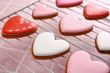 Grid with tasty heart shaped cookies on tile background, closeup