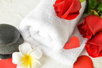 Beautiful spa composition with stones and roses for Valentine's Day celebration on light background, closeup