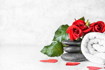 Beautiful spa composition with stones and roses for Valentine's Day celebration on light background