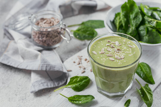Glass of homemade healthy green smoothie with fresh baby spinach