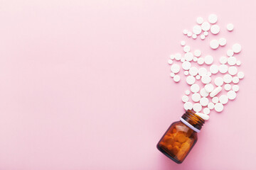 Medicine pills and bottle on pink background