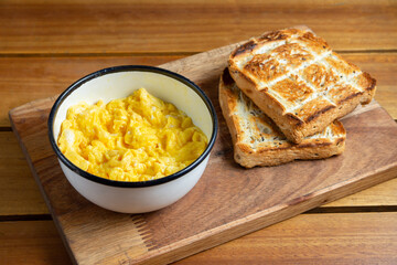 desayuno con huevos revueltos y pan tostado