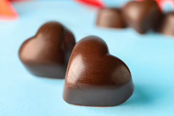 Tasty heart-shaped candies on blue background, closeup