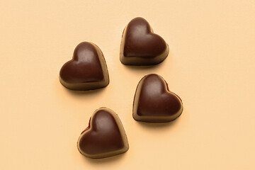 Obraz na płótnie Canvas Tasty heart-shaped candies on beige background