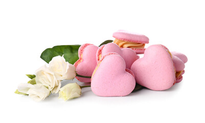 Tasty heart-shaped macaroons and flowers on white background