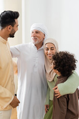 Fototapeta premium interracial muslim family embracing while looking at each other at home.