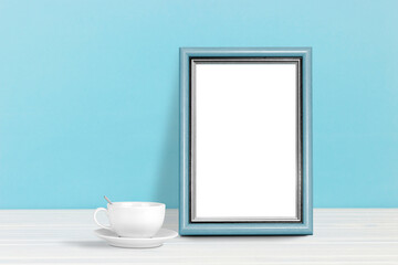 Fototapeta na wymiar Poster template. Photo frame on wooden table with coffee cup