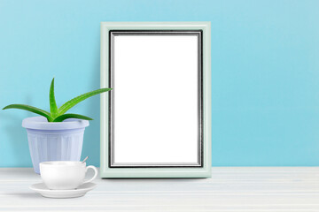 Poster template. Photo frame on wooden table with homemade flower and cup of coffee