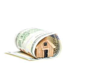 Miniature wooden house wrapped in a dollar bill